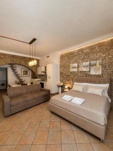 a bedroom with a large bed and a couch at Giulivi Assisi Apartments in Assisi