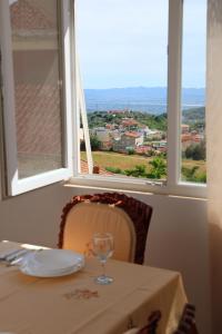 a table with a wine glass sitting in front of a window at Joni s Guest House in Krujë
