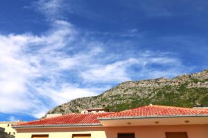 a building with red tile roofs and a mountain at Joni s Guest House in Krujë