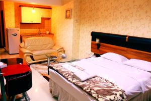 a bedroom with a bed and a chair in it at The Apartments By Sedrah in Irbid +6 photos