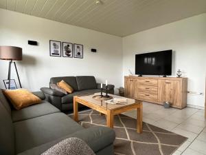 a living room with a couch and a tv at Große Auszeit in Gammendorf