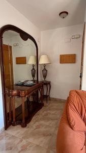 a living room with a table and a mirror at Casa Rural Tío Cuchi in Bolbaite