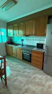 a kitchen with wooden cabinets and a stainless steel refrigerator at Casa Rural Tío Cuchi in Bolbaite +15 photos