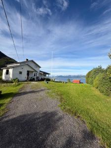 a house on the side of a road next to a field at Oldervik Sea House in Tromsø