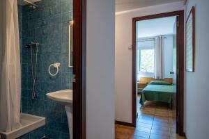 a bathroom with a sink and a toilet and a bed at AT121 Con piscina y cerca de la playa in Torredembarra