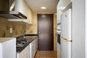 a kitchen with white cabinets and a white refrigerator at AT121 Con piscina y cerca de la playa in Torredembarra