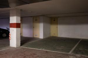 an empty parking garage with three columns and a car at AT121 Con piscina y cerca de la playa in Torredembarra