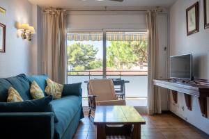 a living room with a blue couch and a tv at AT121 Con piscina y cerca de la playa in Torredembarra