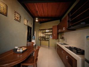 a kitchen with a wooden table and chairs in a room at Audi's Homestay near Kotagede in Gondowulung