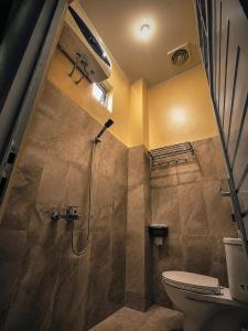 a bathroom with a shower and a toilet at Audi's Homestay near Kotagede in Gondowulung +14 photos