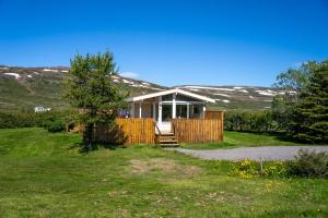 a house in the middle of a yard at Hvammur 1 with private hot tub in Drangsnes