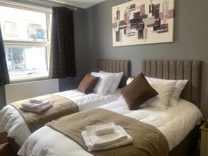 two beds sitting next to each other in a bedroom at Holiday home with 3 double bedrooms all En-suite in Craven Arms