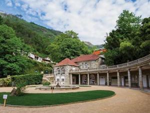 a large stone building with a fountain in a courtyard at Mélita Guesthouse in Braga