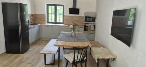 a kitchen with a wooden table and a refrigerator at House by the water in Lesík