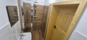 a bathroom with a shower and a toilet and a door at House by the water in Lesík