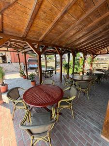 a patio with tables and chairs under a wooden roof at Vila Patricia in Eforie Sud