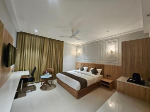 a hotel room with a bed and a desk at Hotel Trimurti By Carlton Suites in Ayodhya +3 photos