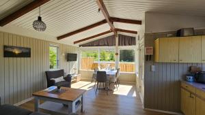 a living room with a table and a dining room at Hvammur 1 with private hot tub in Drangsnes