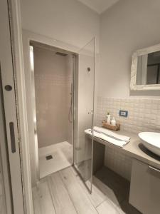 a bathroom with a glass shower and a sink at Monolocale Incantevole in Montichiari