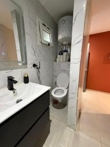 a bathroom with a white sink and a toilet at Résidence les maquis in Koungou