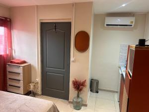 a room with a door and a vase with a plant at Résidence les maquis in Koungou