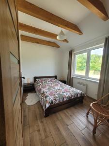 a bedroom with a bed and a window at Domki Strumieniowa in Wólka Tanewska