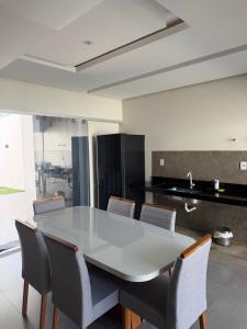 a kitchen with a white table and chairs at Casa no Bairro Reserva Real in Montes Claros