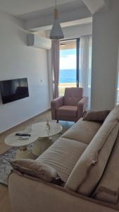 a living room with a couch and a table at Rafailovici Beachfront Apartment in Budva
