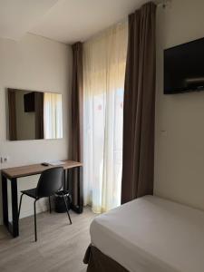 a hotel room with a bed and a desk and a chair at Hotel Victoria Centro in Almuñécar