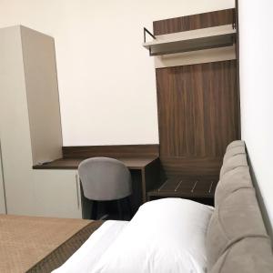 a bedroom with a bed and a desk and a chair at Savuto Affitta Camere in Martirano