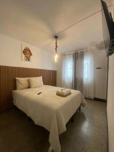 a bedroom with a large white bed with white sheets at Los Aposentos Antigua in Antigua Guatemala