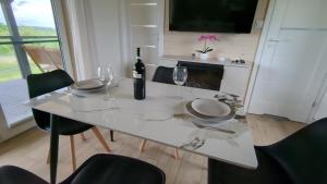 a dining room table with a bottle of wine and glasses at Dom nad wąwozem in Sandomierz