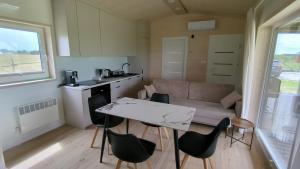 a kitchen and a living room with a table and chairs at Dom nad wąwozem in Sandomierz