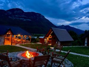 a fire pit in the yard of a cabin with a mountain at Lagano Mountain Retreat - Via Ferrata & Restaurant in Gusinje