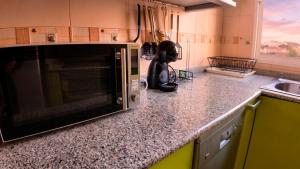 a kitchen with a microwave on a counter at Apartalux Cielo Dorado in San Juan de los Terreros