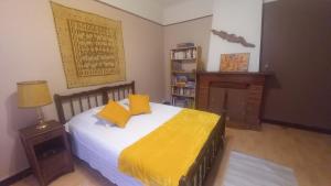 a bedroom with a bed with two yellow pillows at Chez Valérie côté Sud in Saint-Jean-du-Gard