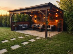 a pergola with couches and tables in a yard at Vila Matt in Vama Veche