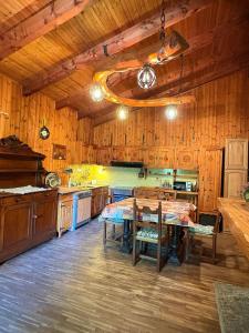 a kitchen with wooden walls and a table and chairs at Baita immersa nel verde in Salabertano