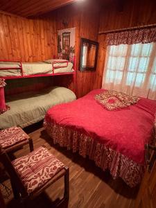 a bedroom with two bunk beds and a red blanket at Baita immersa nel verde in Salabertano