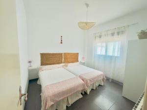 a white bedroom with a bed and a window at Villabett Caudiel está de moda in Caudiel