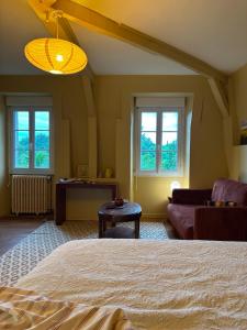 a bedroom with a bed and a couch and windows at La Pépite in Sénac +21 photos
