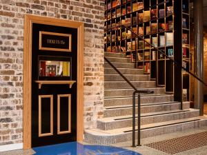 a staircase leading to a library with a door and books at 25hours Hotel Sydney The Olympia in Sydney