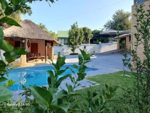 a villa with a swimming pool and a house at Duco self-catering in Nelspruit