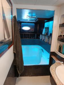 a bathroom with a blue tub and a sink at The boathouse in Benalmádena