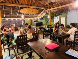 a group of people sitting at tables in a restaurant at Blue Wings Arugam Bay in Arugam Bay