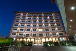 un edificio de hotel con una fachada iluminada por la noche en Hotel Calissano en Alba