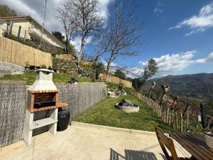 a backyard with an outdoor grill in a yard at Refúgio da Mariana - Gerês in Terras de Bouro