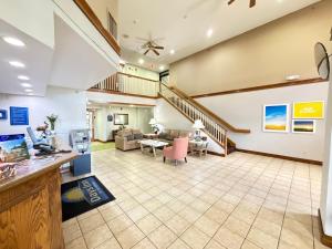 an open living room with a staircase and a living room at Days Inn & Suites by Wyndham Cuba in Cuba