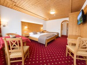 a hotel room with a bed and two chairs at Hotel Bechlwirt in Kirchberg in Tirol