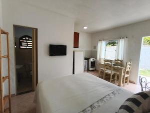 a bedroom with a bed and a table and a kitchen at Solares Boa Estada in Búzios